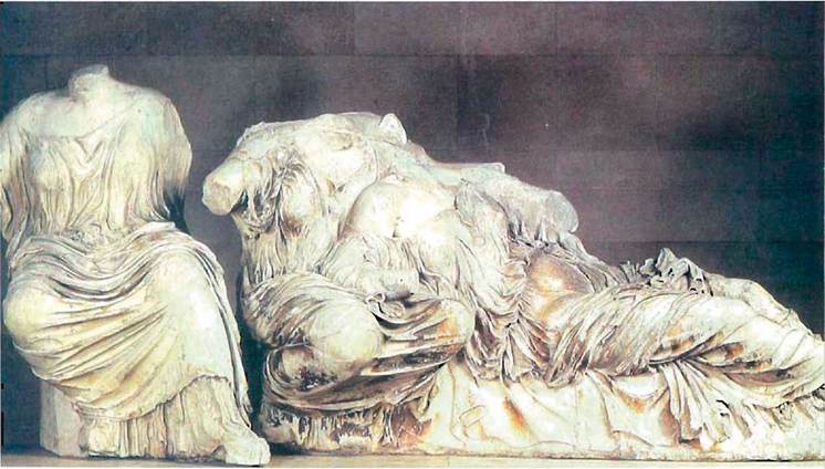Από την παράσταση της Γέννησης της Αθηνάς στο ανατολικό αέτωμα του Παρθενώνα, 438-432 π. Χ. Η Εστία (Πειθώ;) και η Αφροδίτη στην αγκαλιά της μητέρας της Διώνης. Λονδίνο, British Museum.