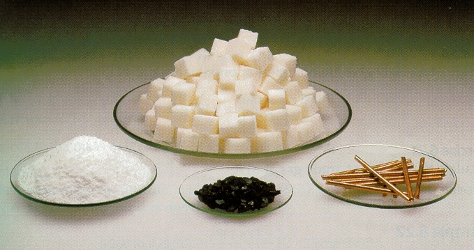 ΣΧΗΜΑ 4.1Από αριστερά προς τα δεξιά ποσότητες 1 mol από : μαγειρικό αλάτι (NaCl),ζάχαρη (C12H22O11): άνθρακα (C), χαλκό (Cu).