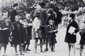 2. Ρακένδυτα και πεινασμένα παιδιά της Κατοχής περιμένουν συσσίτιο.