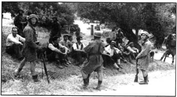 Άοπλοι αναμένουν την εκτέλεση τους από τους Γερμανούς. Φωτογραφία από το Κοντομαρί Χανίων, κρητικό χωριό που κατέστρεψαν ολοκληρωτικά οι κατοχικές δυνάμεις, στις 3 Ιουνίου 1941, σε αντίποινα για την αντίσταση των πολιτών του κατά τη μάχη της Κρήτης.
