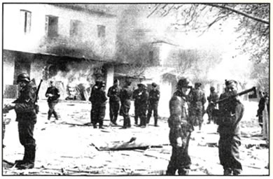 Στις 10 Ιουνίου 1944 ο γερμανικός στρατός πυρπόλησε το Δίστομο, αφού εξόντωσε τον άρρενα πληθυσμό του χωριού. Στη φωτογραφία, Γερμανοί στρατιώτες με φόντο το κατεστραμμένο Δίστομο. 