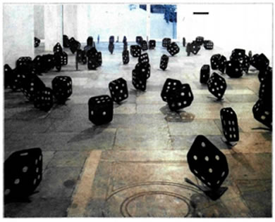 Γιώργος Λάππας (γενν. το 1950), «Ζαριές», 1990, εγκατάσταση, Γκαλερί Jean Bernier, Αθήνα. Θέλοντας να εστιάσει το ενδιαφέρον του θεατή στις έννοιες του τυχαίου και της σύμπτωσης, αλλά και στις δραματικές διαστάσεις που παίρνουν αυτές στη ζωή του ανθρώπου, ο καλλιτέχνης έστησε ένα «παιχνίδι», ρίχνοντας ένα πλήθος από ομοιώματα ζαριών σε διάφορα μεγέθη μέσα σε έναν κυβόσχημο χώρο. Οι συμπτωματικοί συσχετισμοί των ζαριών στο δάπεδο, οι εναλλαγές φωτός και σκιάς υποβάλλουν στον θεατή την αίσθηση της συνεχούς κίνησης και μεταβολής και του μεταδίδουν τον προβληματισμό για τη δύναμη του τυχαίου και τις απρόβλεπτες επιπτώσεις του στη ζωή.